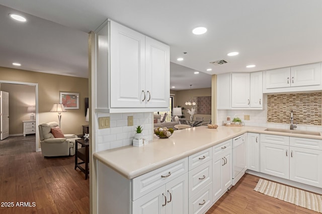 10330 W Thunderbird Blvd Unit A301, Sun City, AZ 85351 - kitchen featuring a sink, dishwasher, wood finished floors, tasteful backsplash, and white cabinets