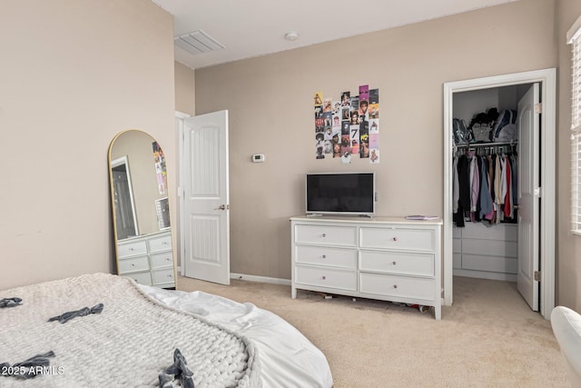 bedroom with light carpet, a closet, and a walk in closet