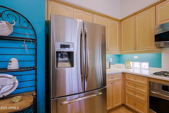 kitchen featuring stainless steel appliances, light countertops, and light brown cabinets