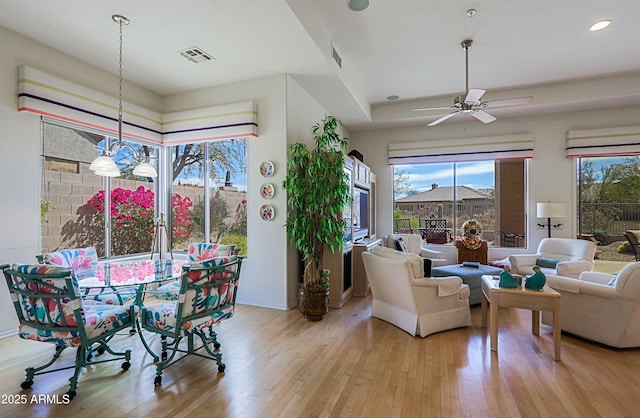 living area with visible vents, ceiling fan with notable chandelier, light wood-style flooring, and recessed lighting