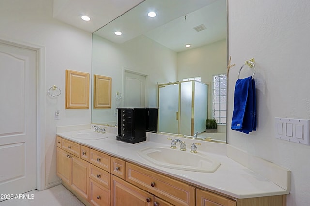 bathroom featuring double vanity, a shower stall, visible vents, and a sink