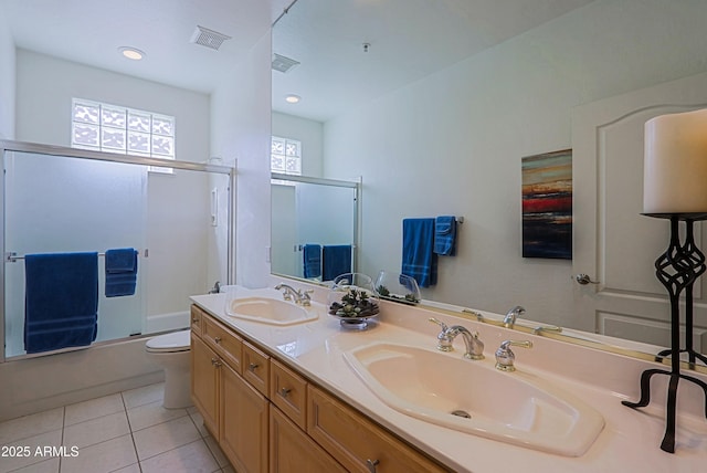 bathroom with double vanity, visible vents, a sink, and tile patterned floors