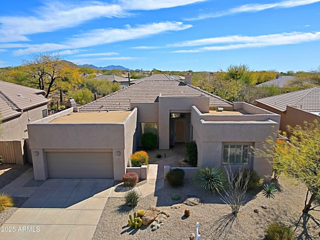 view of front of house with a garage, a mountain view, driveway, and stucco siding