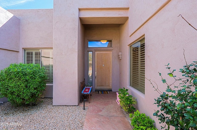 property entrance with stucco siding