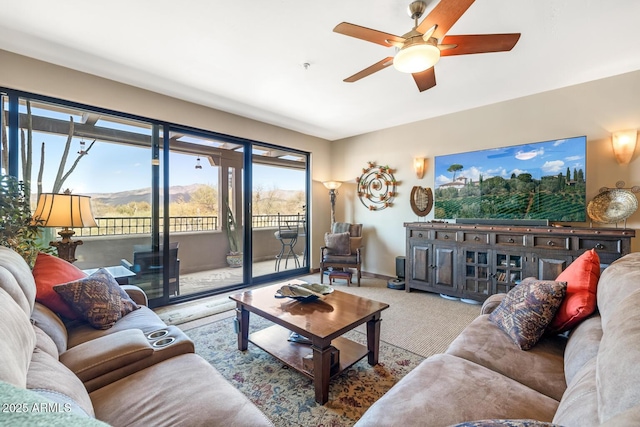 living area with baseboards, carpet floors, and a ceiling fan