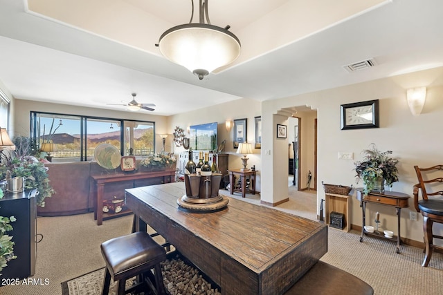 dining room with visible vents, arched walkways, carpet flooring, baseboards, and ceiling fan