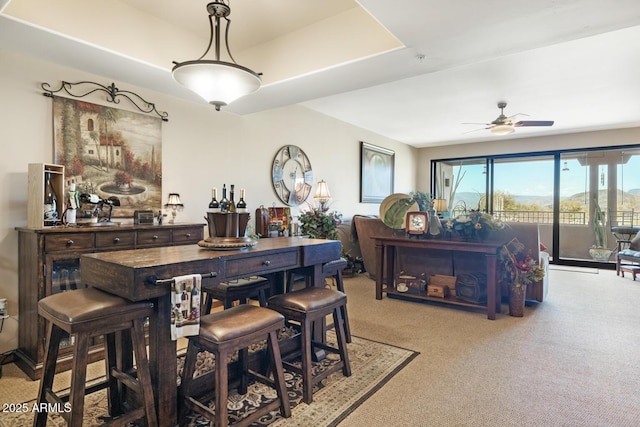 dining area with light carpet and a ceiling fan