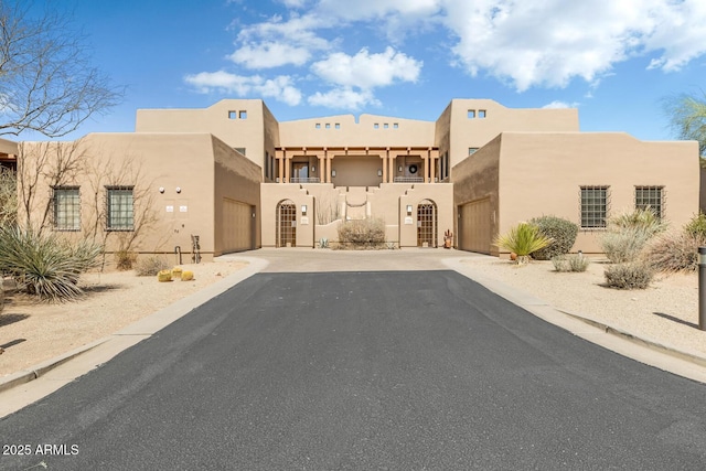 view of front of house with stucco siding, driveway, and a garage