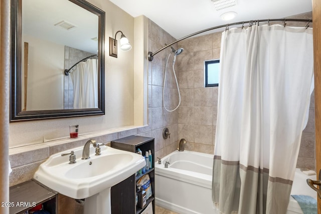 bathroom with visible vents, a sink, and shower / bathtub combination with curtain