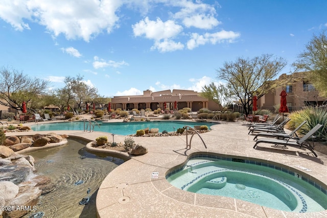 pool with a patio and a community hot tub