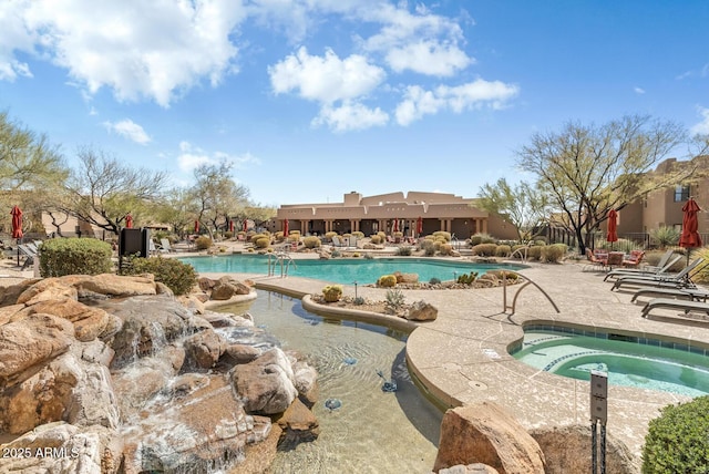 pool with a patio area and a community hot tub