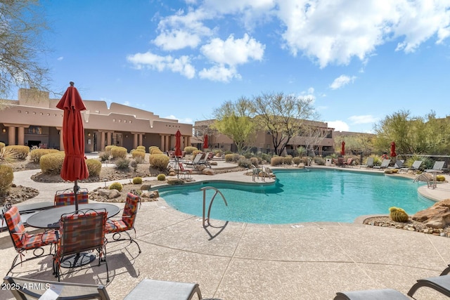 community pool featuring a patio and a residential view