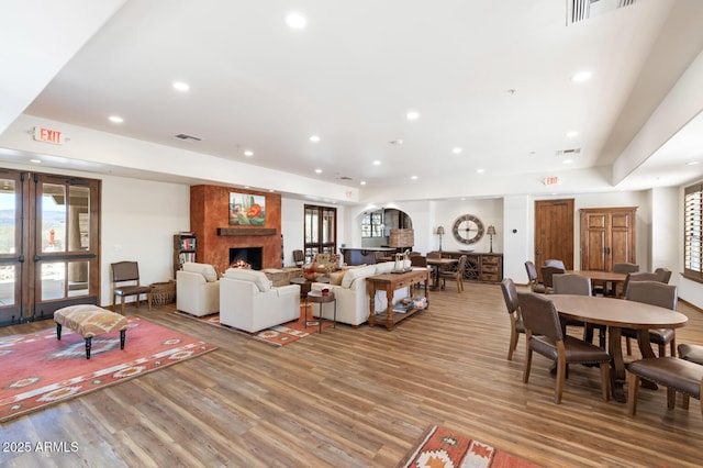 living area with light wood-style floors, recessed lighting, a fireplace, and visible vents