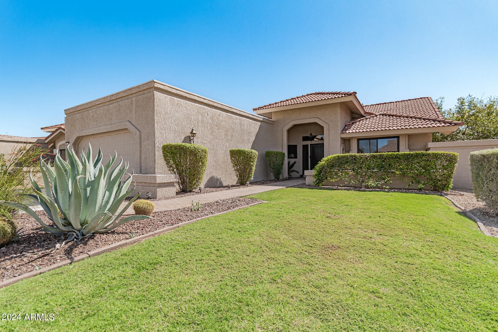 view of front of home featuring a garage and a front lawn