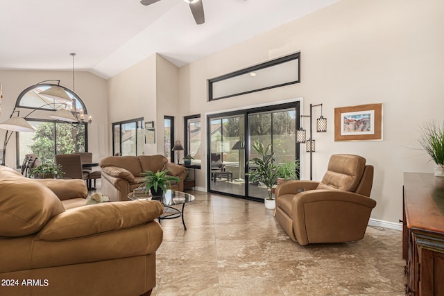 living room featuring a healthy amount of sunlight, ceiling fan with notable chandelier, and high vaulted ceiling