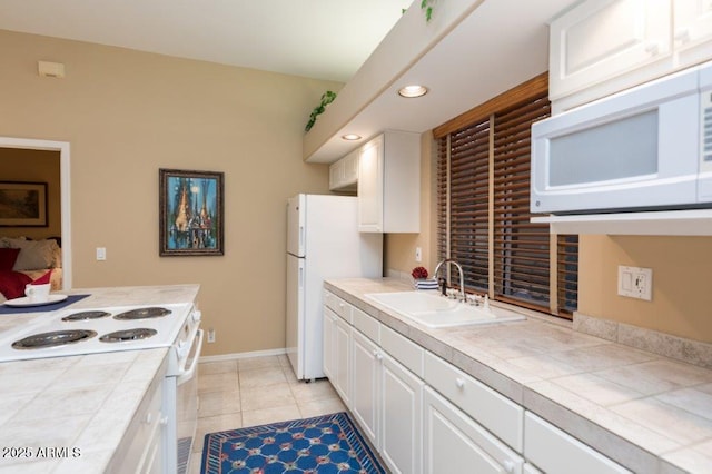 kitchen featuring white appliances, a sink, tile counters, and white cabinetry