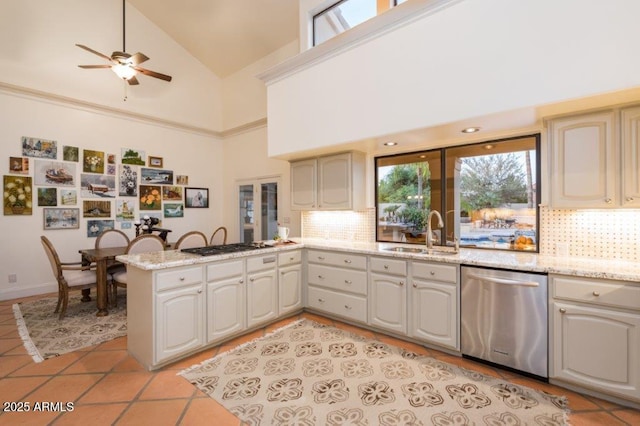 kitchen with a sink, light tile patterned floors, a peninsula, and dishwasher