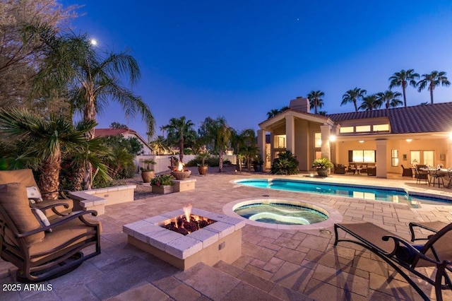 view of swimming pool featuring a fenced in pool, a patio, a fire pit, and an in ground hot tub