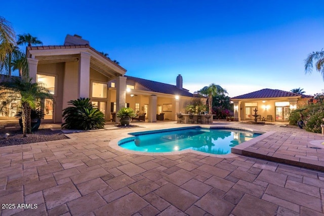 view of pool with a patio and outdoor dry bar