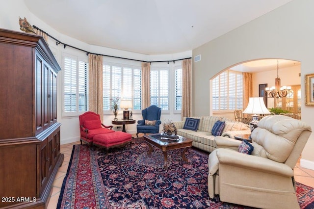 living area featuring visible vents, arched walkways, a notable chandelier, and light tile patterned flooring