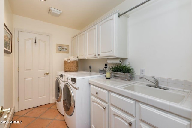 washroom featuring light tile patterned floors, cabinet space, a sink, and separate washer and dryer