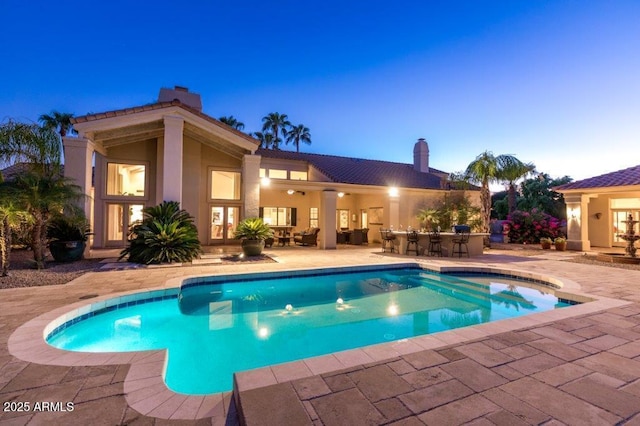 pool featuring french doors, a patio, and outdoor dry bar