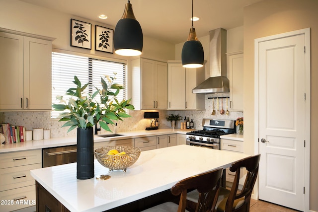 kitchen with gas range, wall chimney exhaust hood, a kitchen breakfast bar, a center island, and backsplash