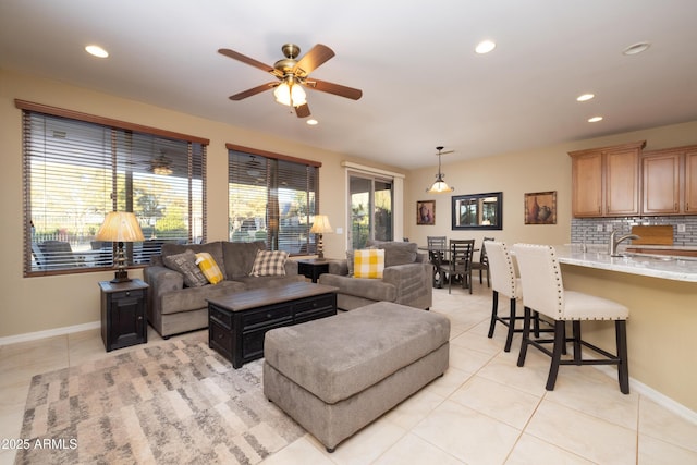 living room with ceiling fan, sink, and light tile patterned floors