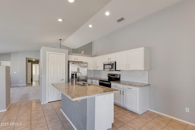 kitchen featuring white cabinets, a kitchen island with sink, lofted ceiling, and stainless steel appliances