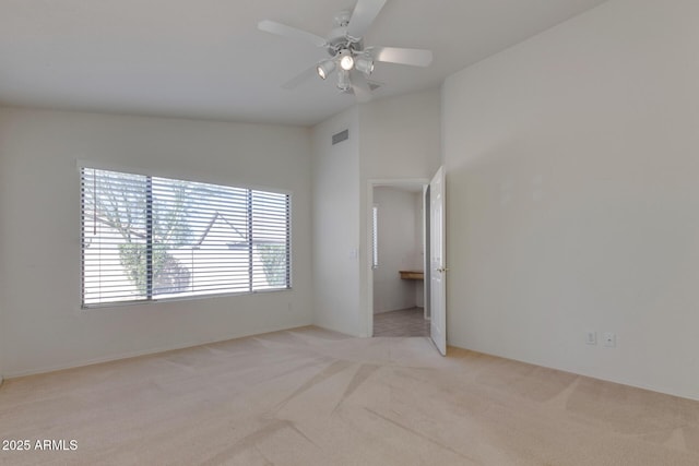 carpeted empty room featuring vaulted ceiling and ceiling fan