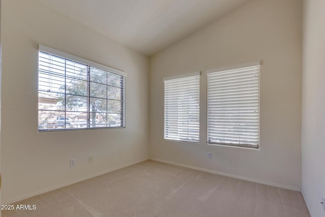 unfurnished room featuring light colored carpet and lofted ceiling