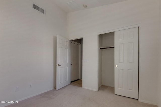 unfurnished bedroom with light carpet and a closet