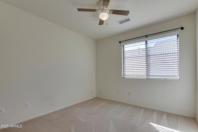 empty room featuring ceiling fan and light carpet