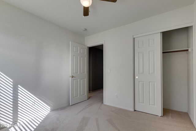 unfurnished bedroom with ceiling fan, a closet, and light carpet