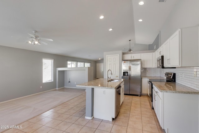 kitchen with vaulted ceiling, sink, white cabinets, an island with sink, and stainless steel appliances