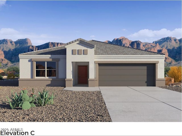 view of front of home with an attached garage, a mountain view, concrete driveway, and stucco siding