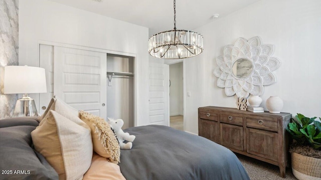 carpeted bedroom featuring a closet and a notable chandelier