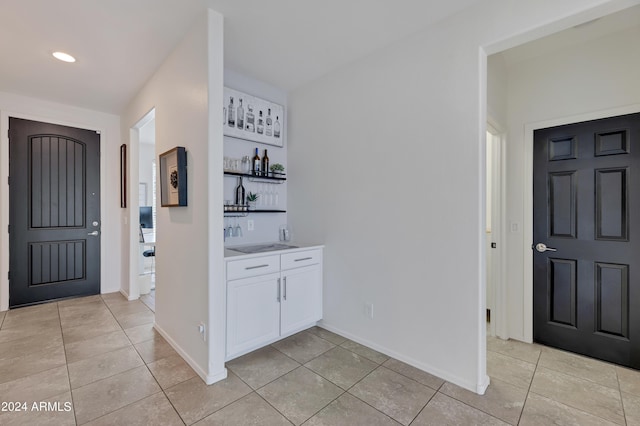 foyer entrance with light tile patterned floors and wet bar