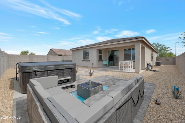 rear view of house with cooling unit, a patio, a hot tub, and outdoor lounge area