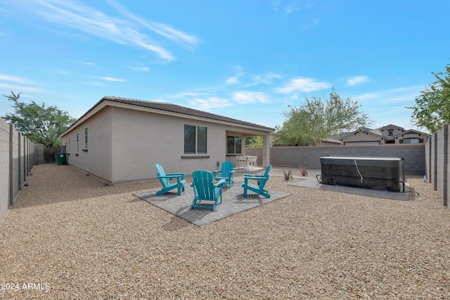 back of house featuring a hot tub and a patio area