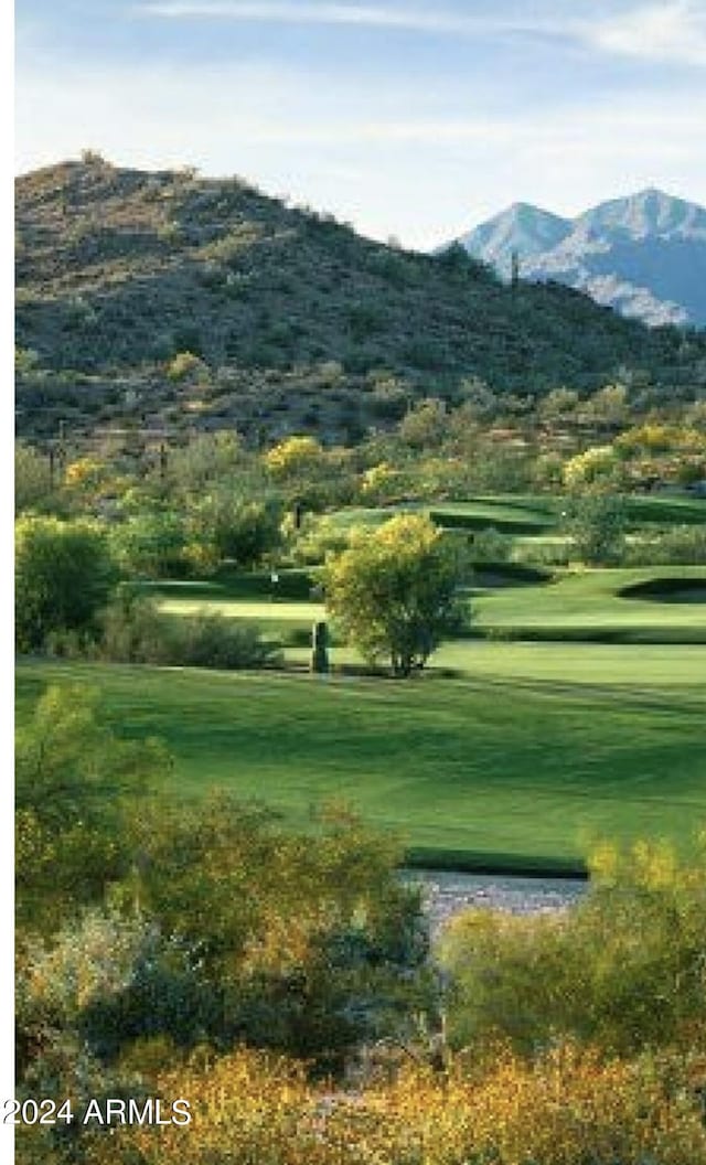 surrounding community featuring a mountain view and a lawn