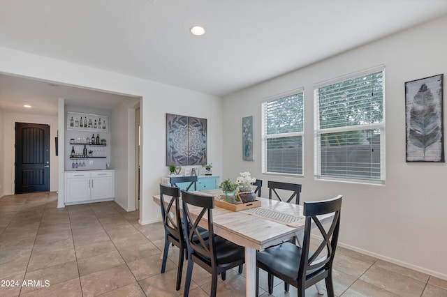 tiled dining area featuring bar area