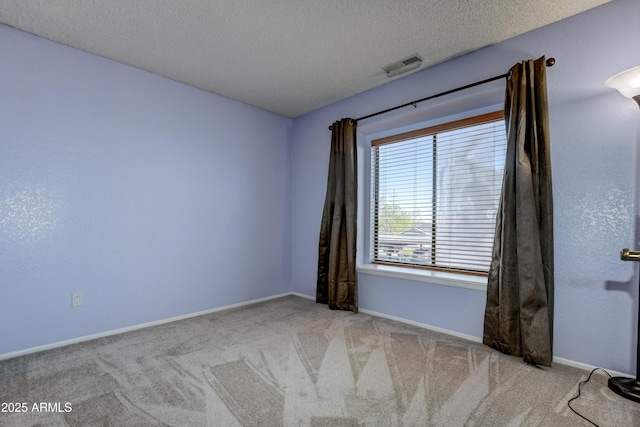 empty room featuring visible vents, a textured ceiling, carpet, and baseboards