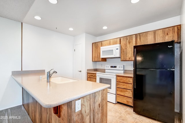 kitchen with a sink, light countertops, recessed lighting, and white appliances