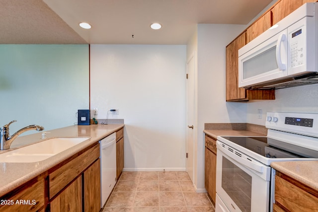 kitchen with white appliances, brown cabinets, and a sink