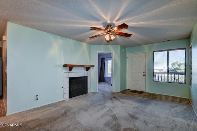 unfurnished living room featuring a textured ceiling, ceiling fan, carpet, and a fireplace