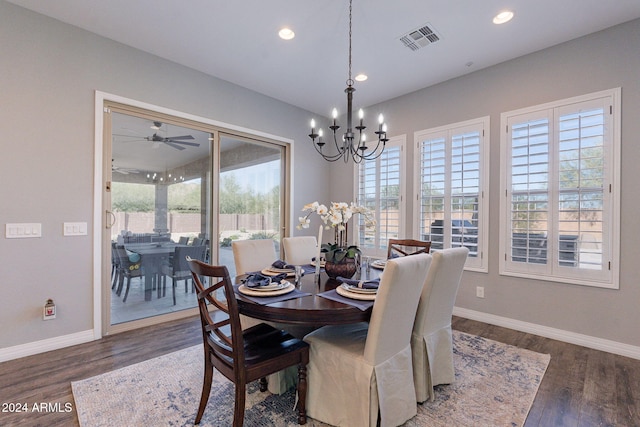 dining area with dark hardwood / wood-style floors, ceiling fan with notable chandelier, and a wealth of natural light