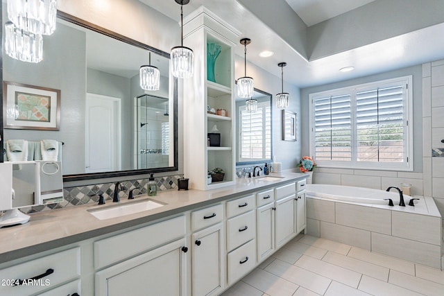 bathroom featuring a notable chandelier, vanity, and independent shower and bath