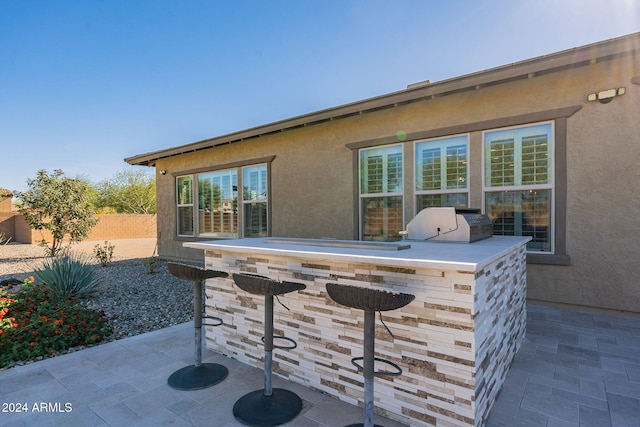 view of patio / terrace featuring exterior bar, an outdoor kitchen, and area for grilling