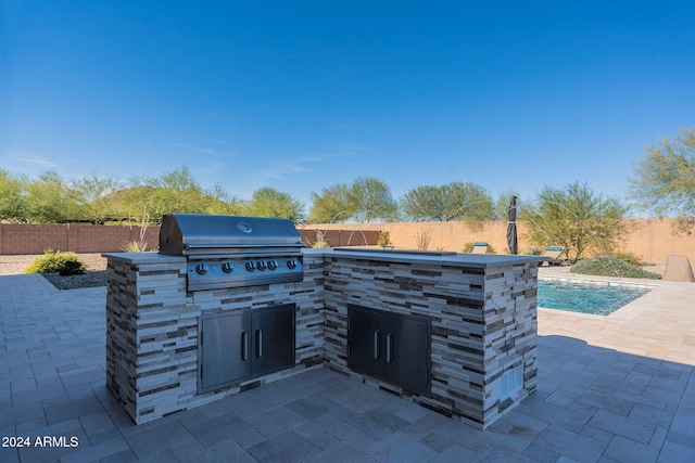 view of patio / terrace featuring a fenced in pool, area for grilling, and a grill